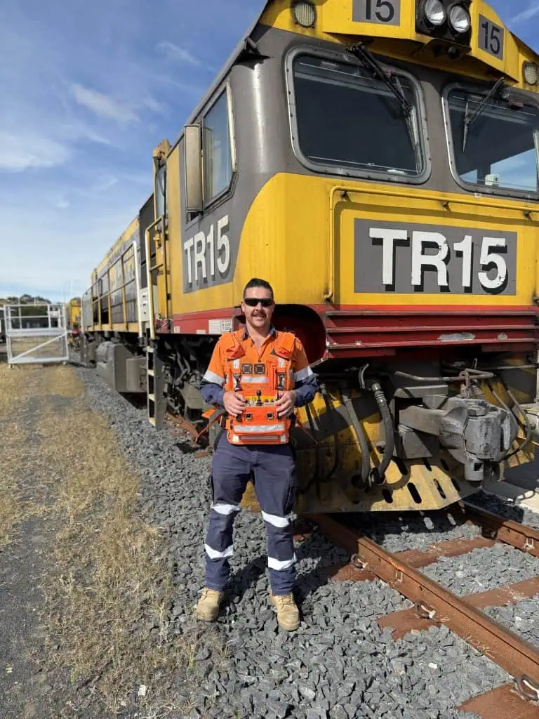 locomotive operator in front of train with cattron locomotive remote control
