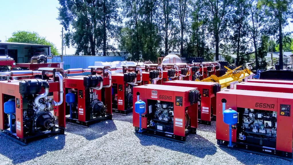 group of red mobile generators sitting outside in the sun