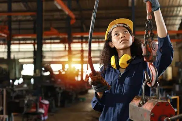 An operator holding a wired pendant control for a jib crane.