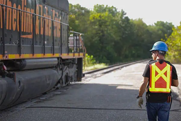 rail operator walking next to a train